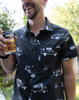 white man wearing rowdee weekender shirt in black holding a beer and smiling.