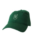 green rock on hat with rock on hand sign in cream on white background.